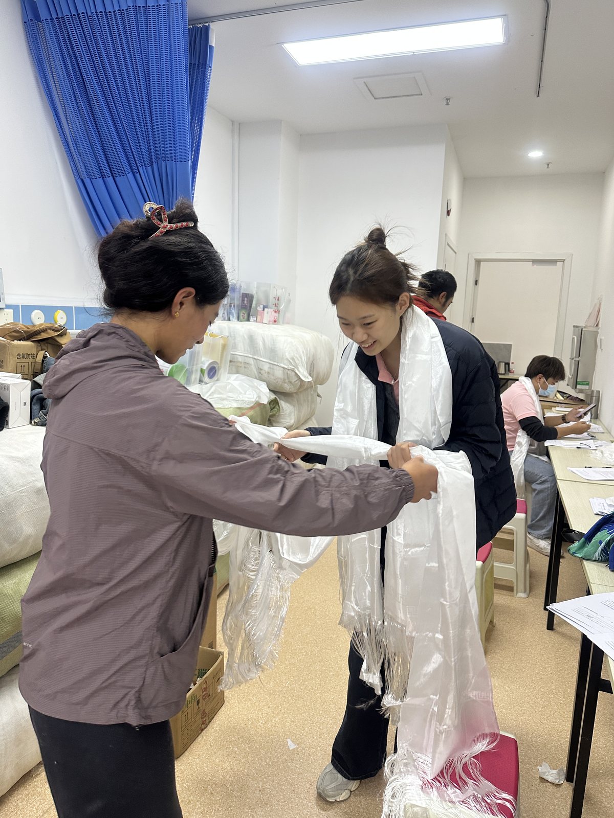 A volunteer tying a ceremonial white scarf for a family member at the Operation Smile outreach in Nyingchi, Tibet