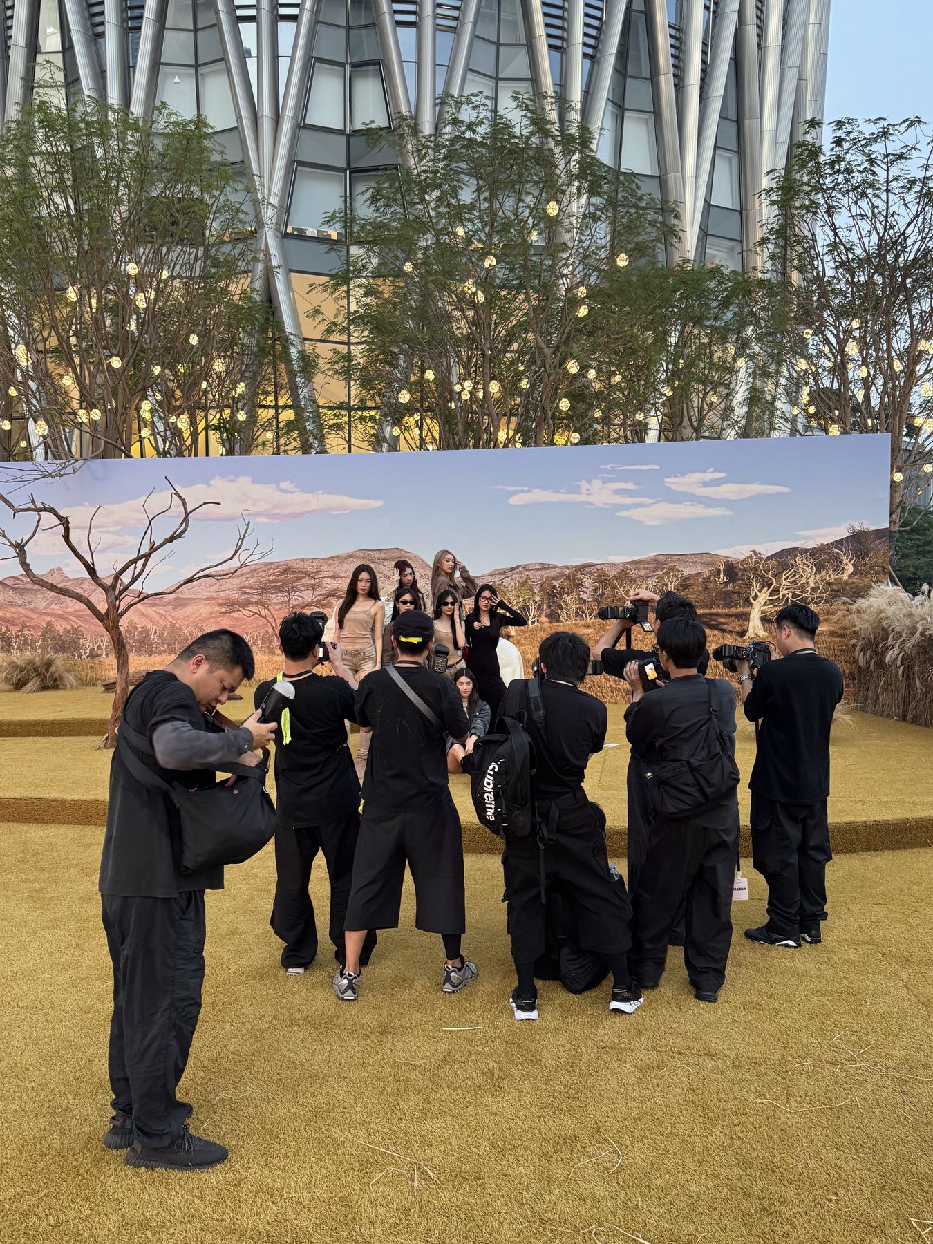 Photographers and crew at a press wall during an outdoor production