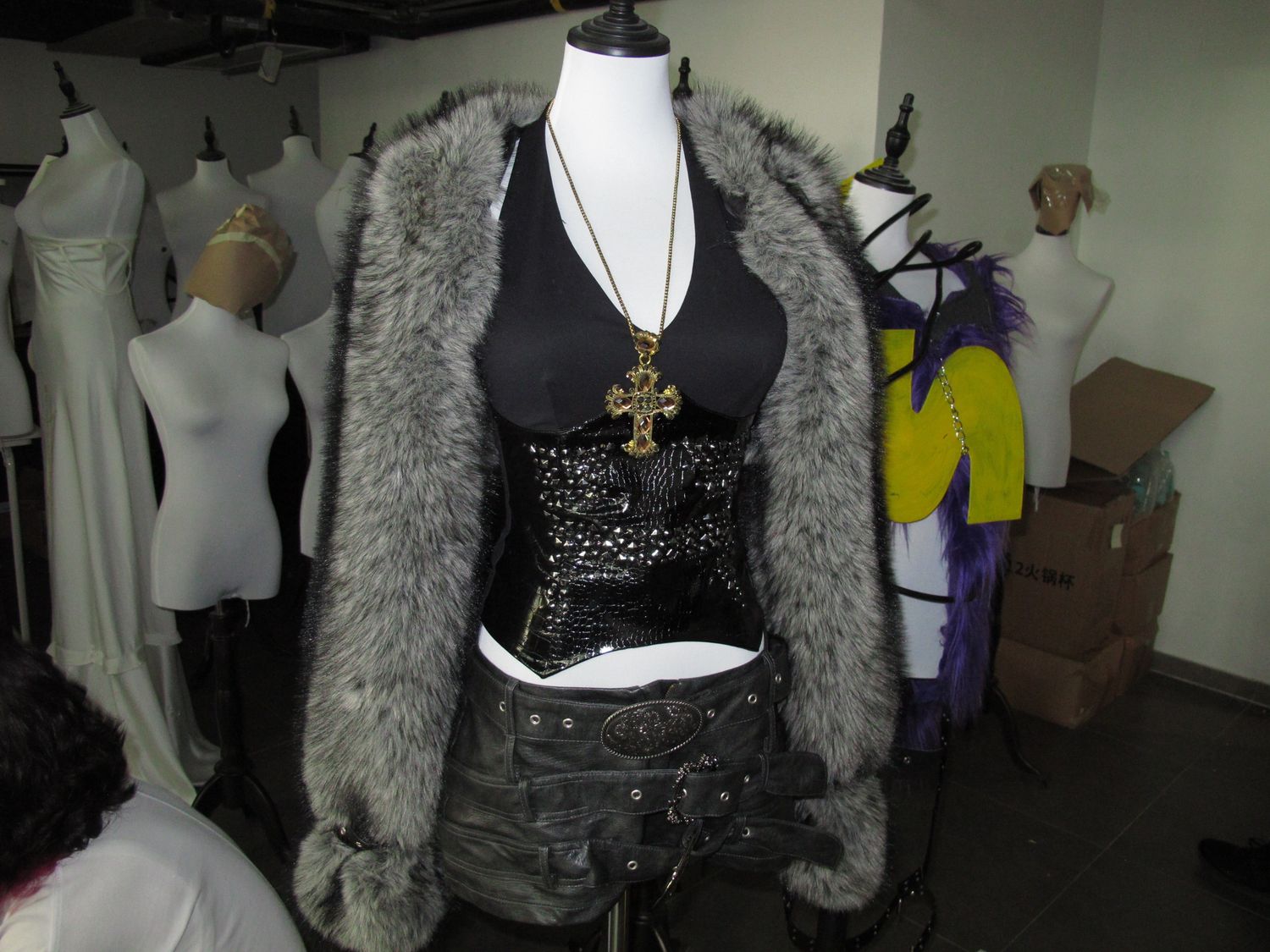 Wardrobe rack of finished looks and a dressed mannequin backstage