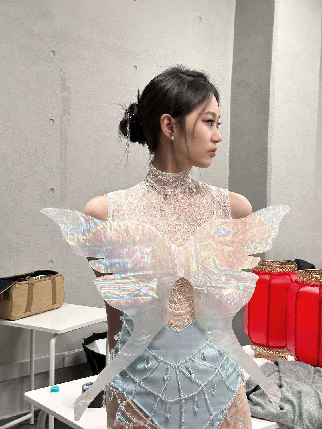 Backstage in a sculptural white gown before the show