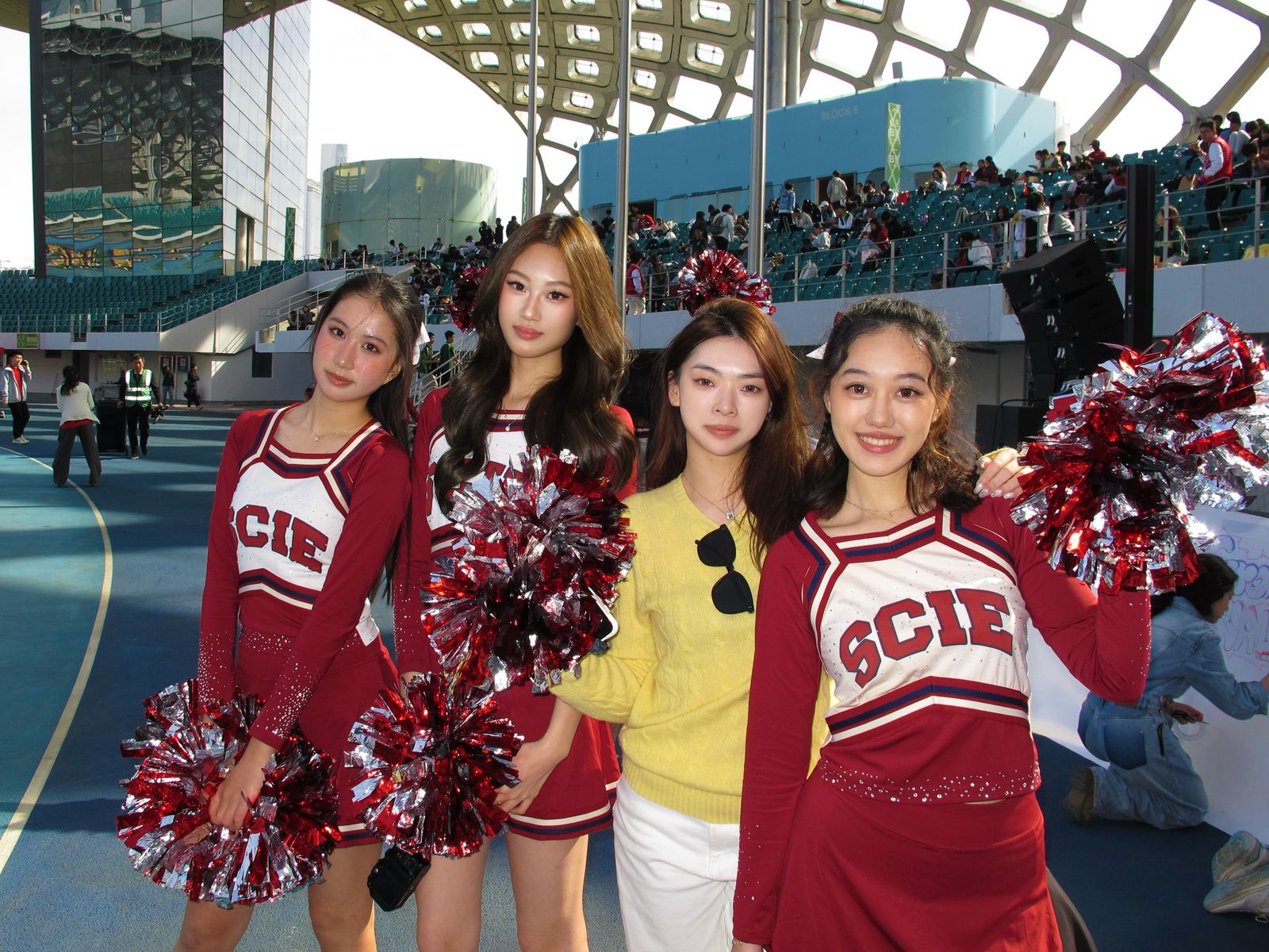 Cheerleaders with pom-poms at a school sports event