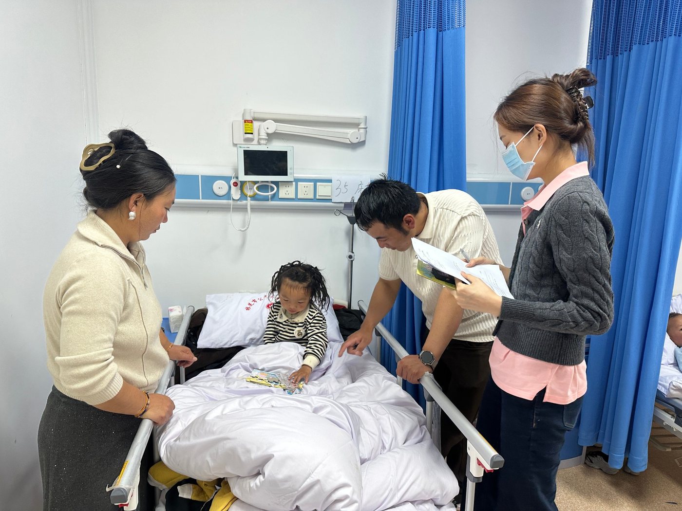 Visiting a young patient with their parents during a medical outreach